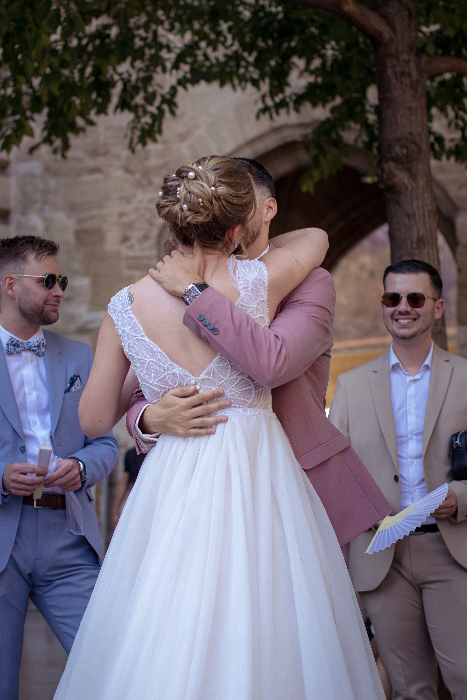 Accolade émue entre la mariée et un proche pendant la cérémonie